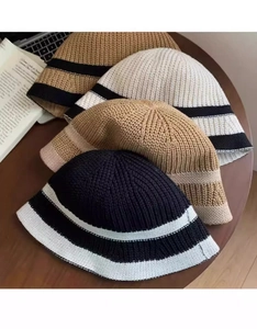 Detail showing various knit bucket hats with stripe patterns in neutral color palette
