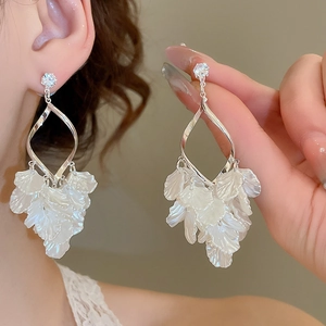 Detail of silver needle drop earrings with pearl petals and sparkling zircons