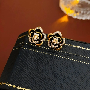 Close-up of elegant black flower earrings with pearls and crystals on jewelry box