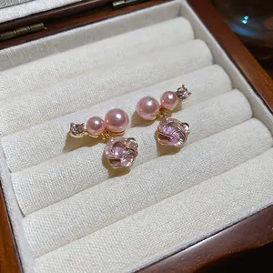 Eleganti orecchini dorati con pendente a fiore rosa e perle lucide da donna