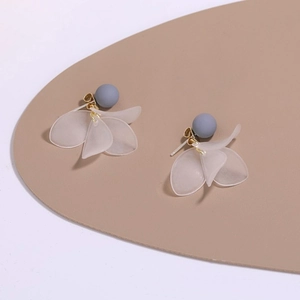 Detailed macro of grey matte beads and translucent frosted petal-shaped drop earrings