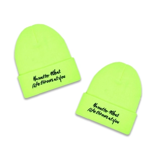 Neon yellow knit beanie with black slogan print for winter warmth and street style