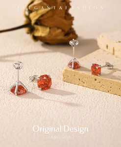 Detailed view of silver S925 earrings with red rose-cut gemstones on stone and floral decor