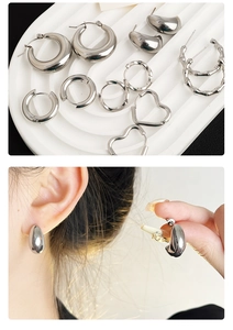 Detailed view of silver bamboo pattern earrings and heart hoops on a white tray