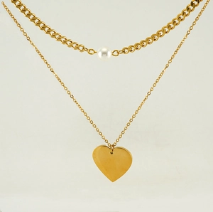 Detail of double-layer gold necklace with white pearl and smooth heart pendant