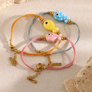 Detailed set of 3 18K gold-plated fish charm woven bracelets in blue, yellow, and pink