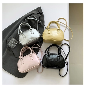 Flat lay of four mini bowling bags in silver, beige, pink and black with leather texture