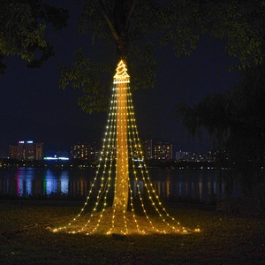 Close-up of LED Christmas star tree topper and warm yellow waterfall string lights on a tree