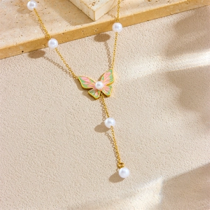 Elegant gold butterfly necklace with pink enamel and pearl tassels on a stone base