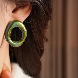 Close-up of moss green resin flower earring worn by a model in vintage style