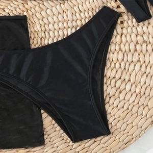 Detail eines schwarzen High-Cut Bikinihöschens aus glänzendem, elastischem Material