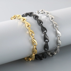Three minimalist stainless steel chain bracelets in gold, black, and silver finishes