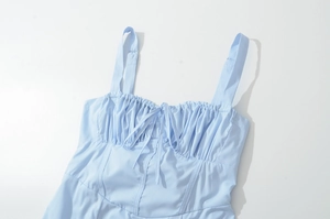 Detail of light blue dress showing pleated chest design and delicate drawstring bow tie
