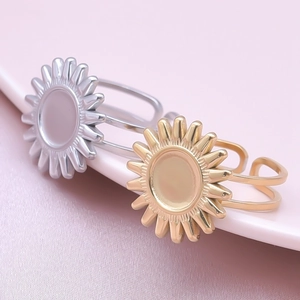 Close-up of gold and silver sunburst rings with round disc base on ceramic dish