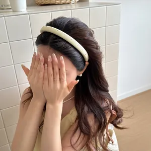 Light yellow satin padded headband with black polka dots shown on a model