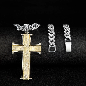 Détail du pendentif croix bicolore serti de diamants et des chaînes cubaines brillantes
