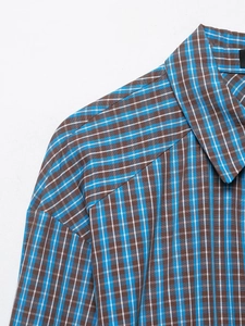 Détail d'une chemise à carreaux bleus et marrons montrant la texture et les coutures du col