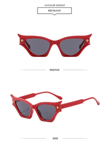 Detail view of red cat-eye sunglasses with sharp bat-wing frame and gold metal logo
