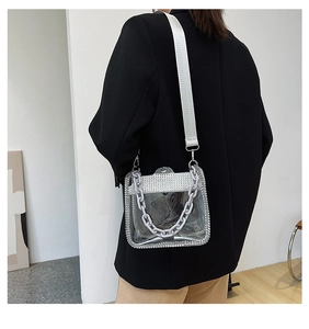 Close-up of transparent PVC handbag with silver rhinestone trim and grey chain handle