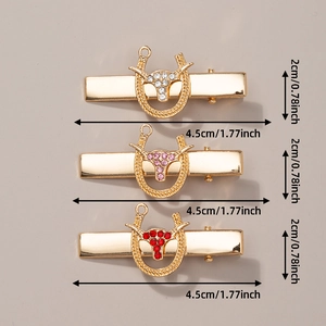 Detailed view of three gold-tone metal hair clips with turquoise and rhinestones