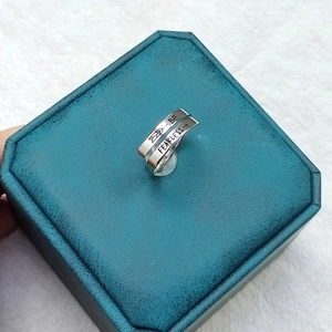 Detail of silver wrap ring with BE FEARLESS engraving on textured jewelry box
