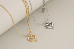 Detailed macro view of hollow heart pendants with sparkling zircons on snake chains