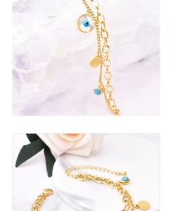 Details des doppelreihigen Titanstahl-Armbands mit Evil Eye und Muschel auf Marmor