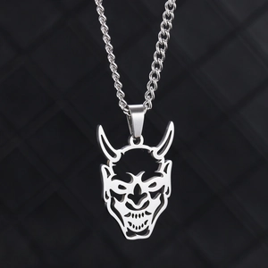 Gros plan détaillé d'un pendentif masque Hannya en acier argenté sur une chaîne torsadée