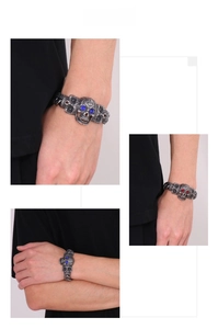 Détail d'un bracelet punk tête de mort avec yeux en strass rouges et chaîne en acier