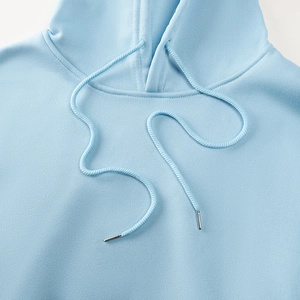 Gros plan du cordon de serrage bleu clair du sweat à capuche et embouts métalliques