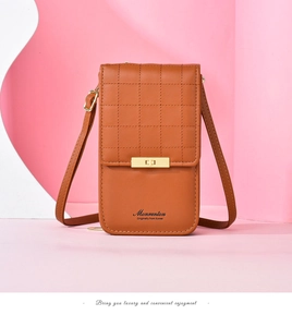 Detail of caramel crossbody bag featuring quilted texture and a gold metal buckle