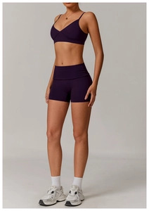 Detailed view of dark purple sports bra and high-waisted shorts with moisture-wicking fabric