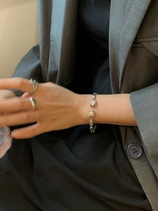 Detail of vintage silver thorn rose open bracelet and matching ring on model hand