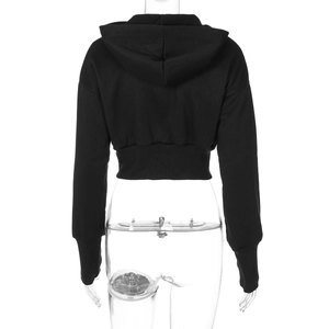 Back view of a black cropped zip-up hoodie featuring ribbed cuffs and hem on a mannequin