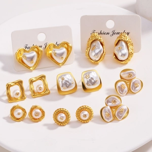 Détails de boucles d'oreilles fleuries plaquées or 18 carats avec perles sur plateau blanc