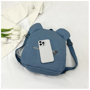 Detailed macro view of denim blue mini backpack with cute bear ears and metal zipper pocket