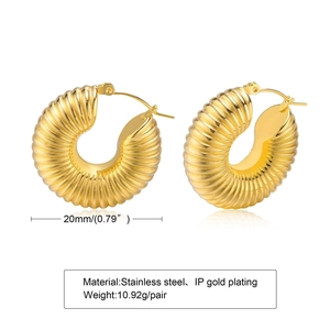 Macro detail of 18K gold plated C-shaped hollow earrings with spiral texture and size marks