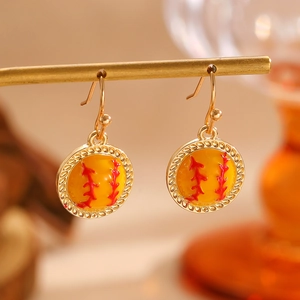 Vue détaillée de boucles d'oreilles de baseball avec couture rouge et cadre doré