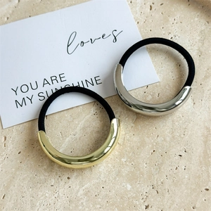 Detail of high-elasticity hair ties with gold and silver polished alloy metal accents