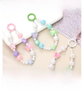 Detail of colorful macaron beaded phone charms with resin hearts and flowers in soft tones