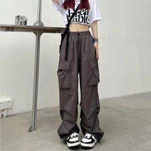 Detail of dark grey cargo trousers with drawstring waist and multiple pockets