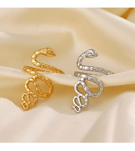Detail of snake rings in gold and silver finishes on elegant satin fabric