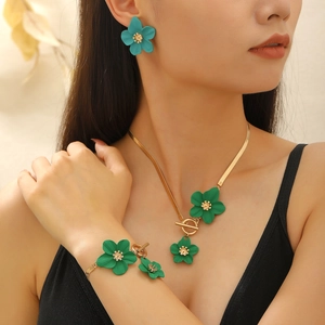 Chic green flower necklace and earring jewelry set worn by a model in soft studio lighting