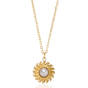 Elegant gold sunburst pendant necklace with a white pearl on a minimal chain