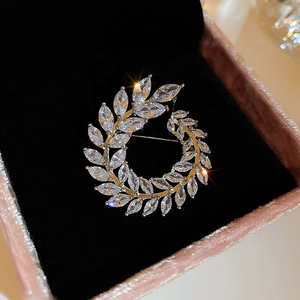 Macro shot of silver wheat leaf brooch with marquise-cut zircons on a black velvet box