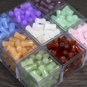 Macro shot of 9 colors of bamboo-shaped glass beads in individual clear boxes for DIY jewelry