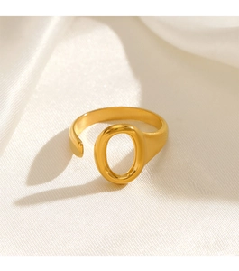 Close-up of a gold-plated oval open ring on elegant white silk fabric with soft shadows