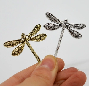 Detailed macro of vintage dragonfly hair clips with intricate hollow wing patterns