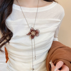 Detail of flower pendant necklace featuring brown mesh petals and champagne rhinestones