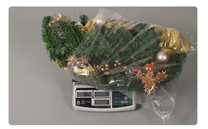 Guirnalda de Navidad con agujas de pino y adornos dorados pesada en su empaque